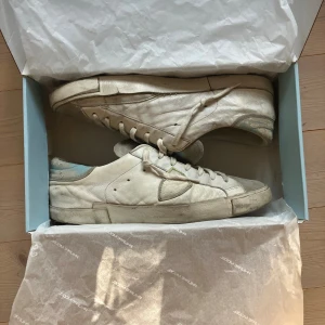 Philippe Model sneakers vit/ljusblå - Säljer ett par feta Philippe Model sneakers i vitt och ljusblått i storlek 43. Skorna är köpt nya och boxen som ni ser på bilden ingår. Om ni har några funderingar tveka inte att kontakta mig. Priset går att diskutera 