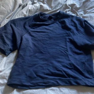 Mörkblå t-shirt från Gina Tricot - En basic mörkblå t-shirt från Gina Tricot i storlek XS. T-shirten har rund halsringning och korta ärmar. Tillverkad i mjukt material som känns skönt mot huden. Perfekt att styla med jeans eller kjol för en enkel look. Byggd för att gå typ under naveln precis PRIS KAM DISKUTERAS