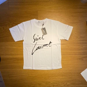 Saint Laurent t shirt  - T-shirt från Saint Laurent 👕 Storlek S ✔️ Helt oanvänd ✔️ Nyskick ✔️ Med tag kvar                     Köpt från leverantör! 📸 Hör av dig vid frågor eller om du vill ha fler bilder! 👉 Kolla gärna in min profil för fler storlekar och modeller.
