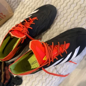 Adidas Predator fotbollsskor svart/röd - Säljer ett par Adidas Predator fotbollsskor. 42. Som nya 