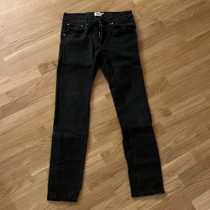 Raka jeans från 157 - Svarta jeans med straight fit från 157. Klassisk femficksmodell med dragkedja och knapp framtill. 