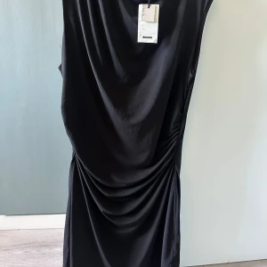 Bik Bok ”Irina” miniklänning - Ärmlös och hög hals med drapering i sidan. Mjuk och stretchig. 