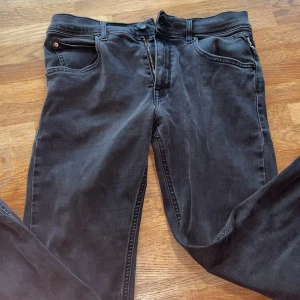 Replay Hyperflex svarta jeans super slim - Svarta Replay Hyperflex jeans med super slim passform. Jeansen har klassisk femficksdesign, dragkedjegylf och diskret Replay-logga vid fickan. Stretchigt material för extra komfort och snygg siluett. Perfekta för dig som gillar en tajt look.