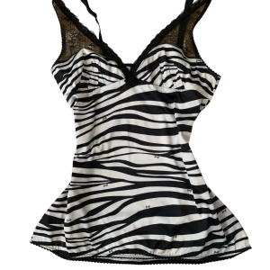 Zebramönstrad linnetopp från D&G - Supersnygg linnetopp från Dolce & Gabbana med svartvitt zebramönster och tunna axelband. Toppen har spetsdetaljer vid bysten och längs kanterna för en extra cool look. Perfekt för dig som vill sticka ut med en unik och trendig topp.