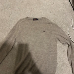 Beige merinoullströja från Morris - använd Max 1-2 gånger nypris 1500. Snygg beige tröja från Morris i 100% merinoull. Klassisk rund halsringning och diskret broderad logga på bröstet. Långärmad och tunnstickad modell som är perfekt för lager-på-lager. Enkel och stilren design som funkar till allt.