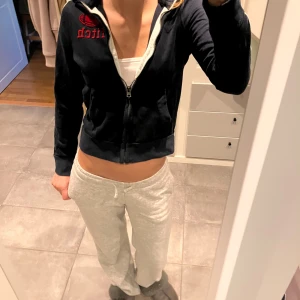 Mörkblå hoodie Abercrombie & Fitch M - Mörkblå hoodie från Abercrombie & Fitch med dragkedja, röda broderade detaljer och vita samt röda ränder på ärmarna. Croppad modell med krage. Den är M i barn storlek så tror den kan igentligen skulle passa någon som har XS/S
