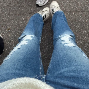 Blå slitna bootcut jeans - Säljer blå jeans från Gina med slitning. Andvända inte