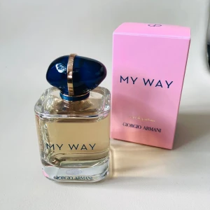 Giorgio Armani My Way Eau de Parfum - Säljer en lyxig parfym från Giorgio Armani, My Way Eau de Parfum, 90 ml. Flaskan är transparent med ljusgul vätska och har en elegant mörkblå kork med gulddetalj. Kommer i en snygg rosa kartong med blå text. Perfekt för dig som gillar exklusiva dofter.