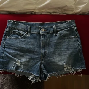 Levi's jeansshorts - Snygga blå jeansshorts från Levi's med fransig och ruffad kant nertill. Väldigt bra skick. Säljer då de tyvärr är för små. 