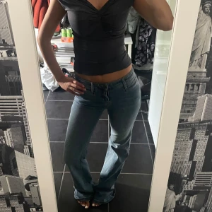 Blå bootcut jeans med låg midja - Säljer ett par klassiska blå bootcut jeans med låg midja. Jeansen har en snygg tvätt, fem fickor och stängs med dragkedja och knapp. Perfekta för dig som gillar en retro vibe och vill ha ett par jeans med lite utsvängda ben. Lite slitna längst ner då det är väldigt långa! Vintage från threesixtyfive. 