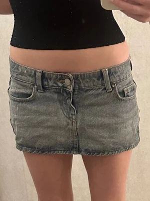 Blå jeanskjol från ONLY - Snygg blå jeanskjol från ONLY i klassisk denim med fem fickor och hällor för bälte. Kort modell med knapp och dragkedja framtill, perfekt för en avslappnad och trendig look.