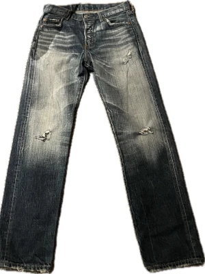 Vintage Levi’s 501 – Distressed Light Wash – W31 L32 - Selling these iconic Levi’s 501s in a perfect sun-bleached light wash. These are naturally distressed with authentic wear and holes, giving them that sought-after vintage grunge aesthetic that you just can't replicate with new jeans. The 501 is the ultimate classic with a straight-leg fit and the signature button fly. These have a lot of character and are ready to be worn as-is for a trashed look or repaired for a DIY-vibe. • Waist: 41 cm • Inseam: 80 cm • Front Rise: 29 cm • Leg Opening: 19 cm 