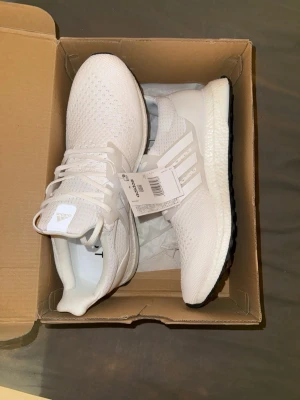 Adidas Ultraboost sneakers - Säljer ett par Adidas UltraBoost i helt nytt skick. Skorna är aldrig använda och har kvar originaltaggar samt kartong. Tillverkade i Adidas Primeknit-material som andas bra och formar sig skönt efter foten. Boost-sulan ger väldigt bra dämpning och komfort, perfekt för vardag, promenader, gym eller casual outfits. Stilren design som passar till det mesta.