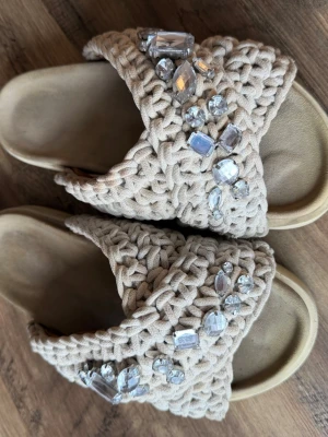 inuikii tofflor  - Säljer ett par vita inuikii tofflor med silvriga stenar. 