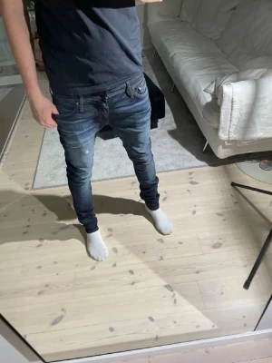 Mörkblå slim fit jeans  - Säljer ett par mörkblå slim fit jeans med snygga slitningar och tvättade detaljer. Jeansen har klassisk femficksdesign, låg midja och smal passform hela vägen ner. Perfekta för dig som gillar en modern och avslappnad stil. Fraktar samma dag i samband med köp av jeansen👍
