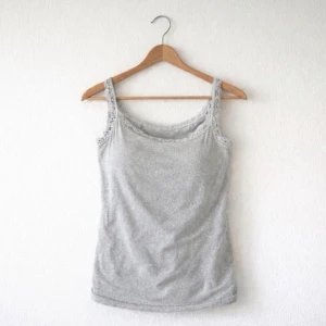 Ljusgrått linne med spetsdetalj från SHEIN, strlk L - Ett enkelt basic och stilrent ljusgrått linne i storlek L med fin spetsdetalj från SHEIN. Köpt secondhand men kommer aldrig till användning! Endast tvättat. Perfekt som basplagg till alla outfits. FÖRST TILL KVARN!