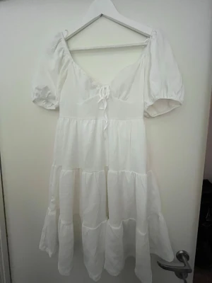 Vit klänning med puffärm - Superfin vit klänning med puffärmar och snörning framtill. Andvänt en gång.