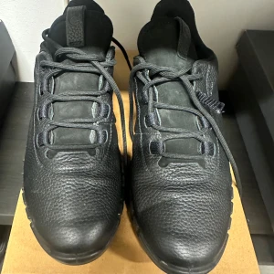 Svarta sneakers från Ecco i läder 39 - Stilrena svarta sneakers från Ecco med chunky sula och ovandel i strukturerat läder. Skorna har svarta snören, diskret logga på sidan och en sportig, modern look. Perfekta för dig som gillar en clean och urban stil.