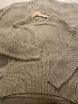 Beige stickad tröja - Stickad tröja i beige. Tröjan har en rak passform och är gjord i ett tjockare garn som ger en mysig känsla. Perfekt för kyliga dagar. Den är helt ny inte använd en enda gång!