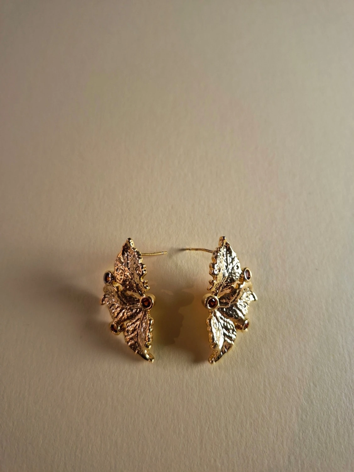 Guldörhängen med löv och röda stenar