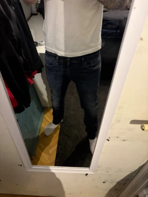 Mörkblå diesel med smal passform - Snygga mörkblå jeans från diesel med klassisk femficksdesign och smal passform och detaljerad logga på fickan. Perfekta för dig som gillar en stilren och modern look. w31 L34