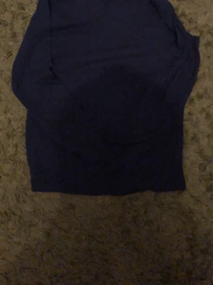 Mörkblå sömlös body - En enkel och stilren mörkblå body i sömlös design. Materialet känns stretchigt och mjukt, perfekt för att sitta bekvämt mot kroppen. Inga synliga märken eller detaljer, vilket ger en clean look. Passar dig som gillar minimalistiska underkläder.