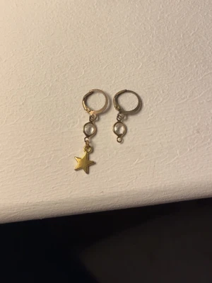 guld örhängen - guldiga örhängen, ett är lite sönder därför billig