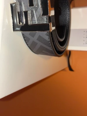 Fendi Bälte - Snyggt svart bälte från Fendi med ett stort, silverfärgat F-spänne. Bältet har ett diskret rutigt mönster och är gjort i skinn. Perfekt för att lyfta vilken outfit som helst med en lyxig touch.