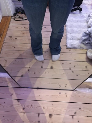 Blå bootcut jeans med fickor - Säljer ett par blå bootcut jeans med klassiska fem fickor och normalhög midja. Jeansen har en snygg tvätt och är tillverkade i denim med lätt stretch för skön passform. Perfekta till en avslappnad stil och passar till det mesta.