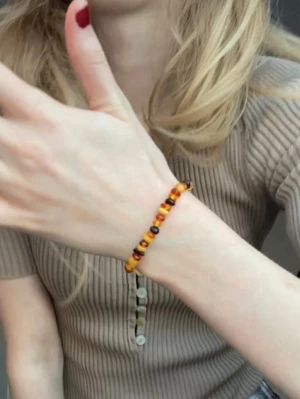 Bärnstensarmband - Ett handgjort armband av äkta bärnsten i både ljust och mörkt. Pärlorna är ganska rundade och sitter på en elastisk tråd som gör armbandet lätt att ta på och av. Såå snyggt och ger verkligen en retro/vintage stil. Älskar att matcha det med andra armband. NOTERA jag har rätt liten handled så skulle säga att det är storlek XS.