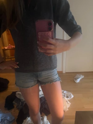 Ljusblå jeansshorts med rå kant - Säljer ett par ljusblå denimshorts med rå, fransig kant nertill. Klassisk femficksmodell och kort passform, perfekta för varma dagar. Snygga att matcha med en enkel t-shirt eller stickad tröja.