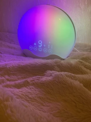 Wake-up light väckarklocka med LED - Säljer en rund wake-up light väckarklocka, som styrs från skärmen samt mobilen. Det ger dig möjligheten att vakna till en soluppgång samt fågelkvitter vilket ger dig en mjukstart på dagen. Det finns 12 olika ljus plus soluppgång samt 7 olika ljus som vågor,regn samt fåglar. Pris kan diskuteras! 