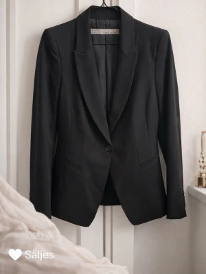 Svart kavaj från Zara Basic - Stilren svart kavaj från Zara Basic med klassisk passform och spetsiga slag. Kavajen har en knapp framtill och två fickor. Perfekt för en snygg och uppklädd look. Materialet känns mjukt och följsamt. Skriv gärna för mer bilder!!! 🤍🤍