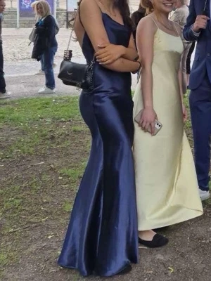 Balklänning mörkblå satin - Säljer min gamla balklänning då den inte kommer till andvändning. Lång, mörkblå klänning i glansigt satintyg. Klänningen har en hög slits framtill, den är perfekt lång för mig som är straxt över 170cm andvänd en gång. Säljer den för 500kr då jag tror nypriset låg lite över 1000kr