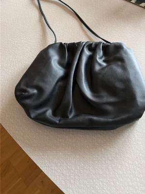 Svart kuvertväska - Stilren svart kuvertväska 