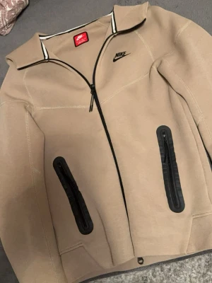 Nike tech - Beige Nike tech, nya modell. Köpt pris 1199kr. Inga defekter Storlek XS