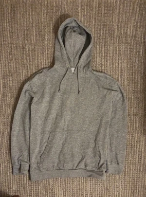 Grå hoodie från Pier One - Snygg grå hoodie från Pier One med klassisk design, huva med snörning och stor magficka. Perfekt för chill dagar och enkel att matcha med jeans eller joggers. Mjuk bomullskänsla och långärmad modell som håller dig bekväm.