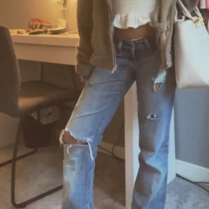 Blå bootcut jeans me hål i  - Blå jeans me hål. De är bootcut och väldigt lågmidjade. Passad någon som är runt 1,53-1,65