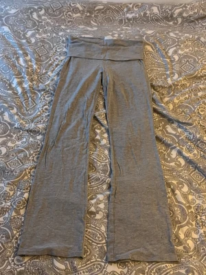 Grå bootcut mjukisbyxor Gina Tricot - Snygga grå mjukisbyxor från Gina Tricot i storlek 158/164. Byxorna har bootcut-ben och bred linning för extra komfort. Tillverkade i mjukt bomullsmaterial med en ljusgrå ton, perfekta för en chill och avslappnad stil.