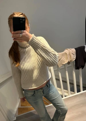 Beige/vit stickad tröja - Säljer en beige/vit, stickad tröja med grov ribbstickning och hög krage. Tröjan har lång ärm och en loose fit som ger en chill vibe. Perfekt att slänga på sig när det är kallt ute. Tröjan är köpt på vinted för 130kr. Skicket är väldigt bra och tröjan är nästan helt ny (det stod det i hennes beskrivning) säljs då jag inte gillade att kragen var lite tajt på mig men annars så sjukt fin🤩Pris kan diskuteras!