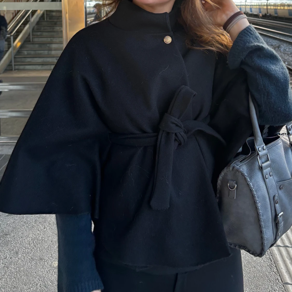 Svart capejacka med bälte och knapp