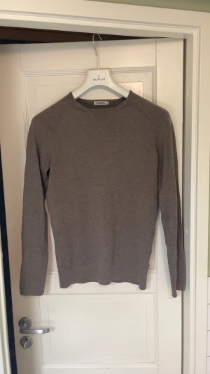 J.Lindeberg tröja  - Snygg brun stickad tröja från J.Lindeberg i storlek S. Tröjan har en enkel och stilren design med rund hals och långa ärmar. Perfekt för dig som gillar klassiska och neutrala färger. Materialet är mjukt och skönt mot huden.