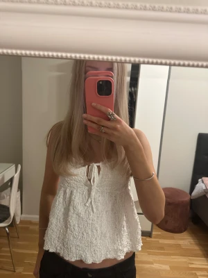 Vit linne med spetsdetaljer från Gina Tricot i stl XS - Supersöt vit linnetopp med tunna axelband i spets. Toppen har en liten knytning framtill och är lätt utsvängd nertill för en luftig känsla. Perfekt för varma dagar!☀️🎀