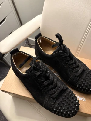 Svarta Louboutin sneakers med nitar - Säljer helsvarta Louboutin med alla taggar kvar, inga större slitningar förutom hälen, pris kan diskuteras 