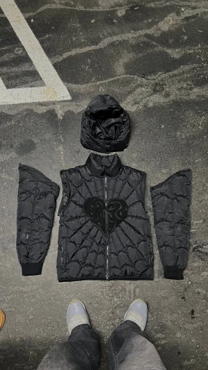 NY* Dreamz™  Svart Quiltad jacka| Avdragsbara ärmar Luva|  - Svart quiltad Spindelnät formad puffer jacka med en  chenille broderad Hjärta centrerad. Baksidan har en hjärt quiltad preciserad form som avliknar framsidan | ALLA STORLEKAR| 70% AV | Säljer snabbt| restock ute nu.  Orginalt pris= 1699kr