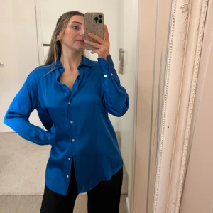 Skjorta - Blå satin skjorta från Zara. Kan bäras upp på olika sätt. Fint material.