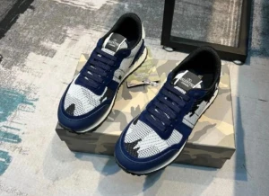 Valentino Rockrunner blå sneakers - Snygga Valentino Rockrunner sneakers i marinblått och vitt med svart camouflagemönster. Ovandelen är i mesh och mocka med skinnpaneler, och har snörning samt platt sula med mönstrad undersida. Perfekt för dig som gillar exklusiva och trendiga sneakers. Pris kan diskuteras!!