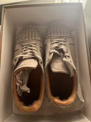 Beige Christian Louboutin sneakers  - Säljer ett par gråa/beigea skor Christian Louboutin. Skorna är använda och pris går att diskutera. Skorna är perfekta för dig som inte vill lägga mycket pengar på ett par fina skor. Skorna är precis såsom på bilden och för fler bilder kan ni skriva till mig. 