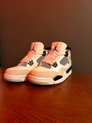 Nike Air Jordan 4 military black  - Nike Air Jordan 4 Retro i vit och svart med meshpaneler, svarta detaljer och klassisk Jumpman-logga på plös och häl. Ovandel i skinn och mocka, snörning framtill och robust sula med synlig Air-enhet. Perfekta för dig som gillar streetwear och sneakers med ikonisk design.