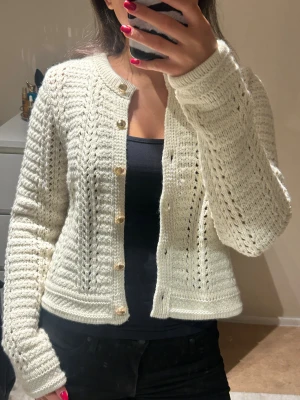 Vit/beige stickad kofta med gulda knappar - Säljer denna fina stickade koftan med gulda knappar i vit/beige färg. Koftan är från H&M i storlek S!